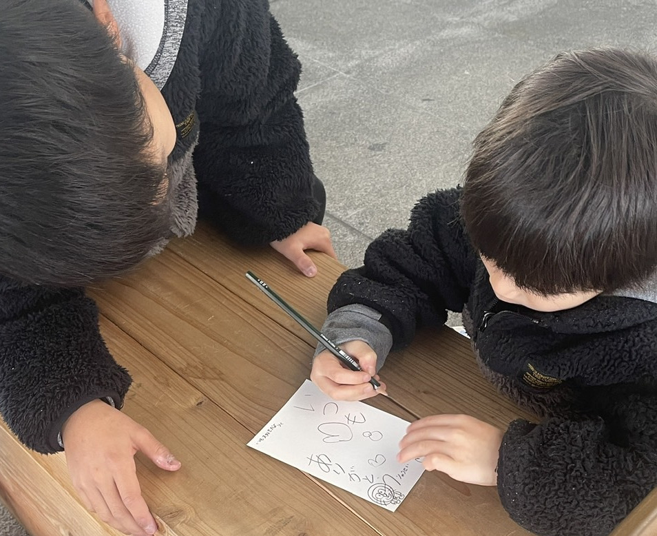 お土産店や駅内コンビニで購入したハガキに旅の想い出やメッセージを書いて