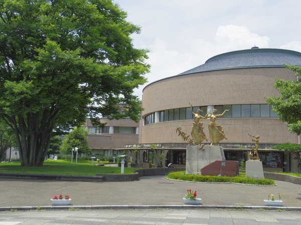緑と彫刻に囲まれた円形の建物
