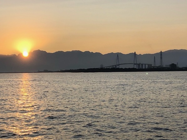観光船から見える日の出と新湊大橋