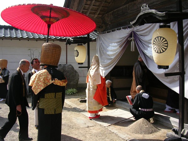 虚無僧に見守られる僧侶