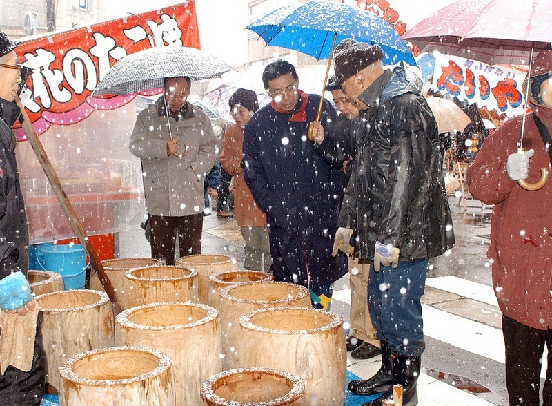 雪の中大勢の人で賑わう歳の大市